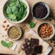 Flat-lay of magnesium-rich foods including pumpkin seeds, almonds, spinach, and black beans