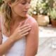 Applying aloe vera gel to sunburned skin next to a fresh aloe leaf
