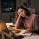 Person sitting exhausted at a desk at the end of a long day, representing the difference between emotional exhaustion and burnout