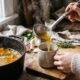Person ladling homemade bone broth into a mug for gut health