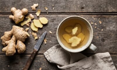 A cup of fresh ginger tea with sliced ginger root for bloating and digestion