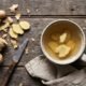 A cup of fresh ginger tea with sliced ginger root for bloating and digestion